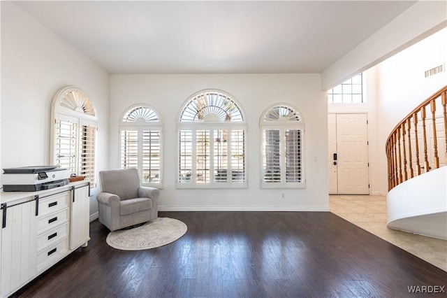 interior space featuring stairway, baseboards, visible vents, and wood finished floors