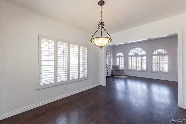 unfurnished room with baseboards and dark wood-style flooring