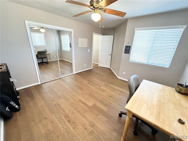 office area with ceiling fan, baseboards, and wood finished floors