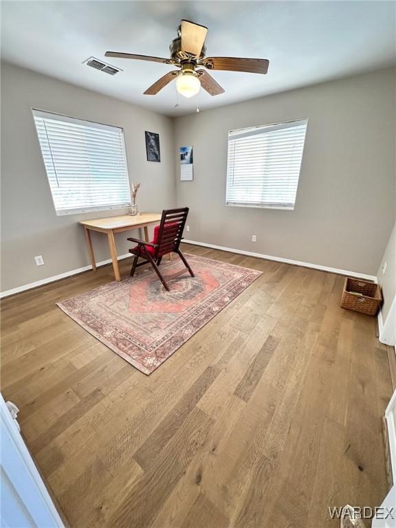 office area featuring wood finished floors, visible vents, and baseboards