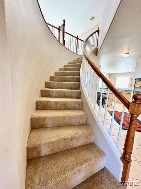 staircase with tile patterned flooring and visible vents