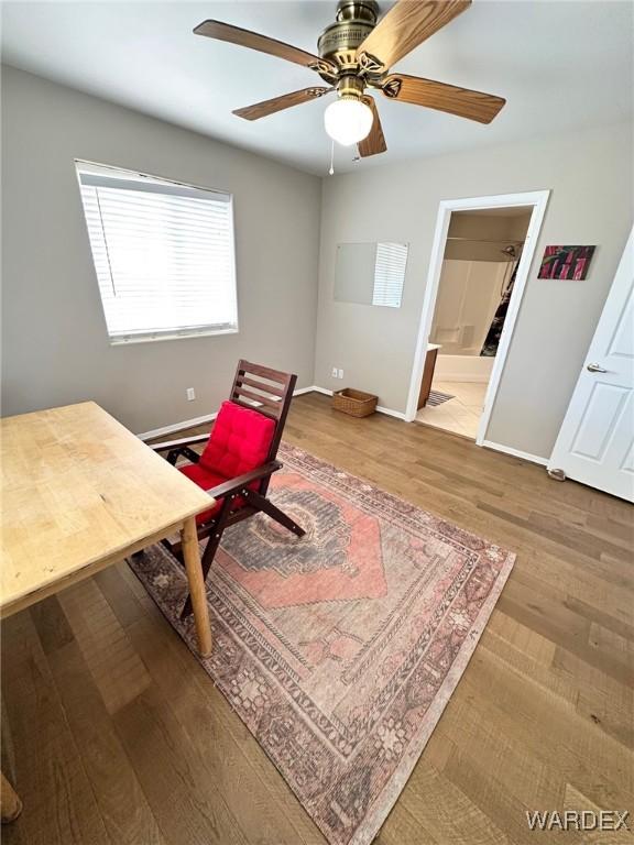 home office featuring a ceiling fan, baseboards, and wood finished floors