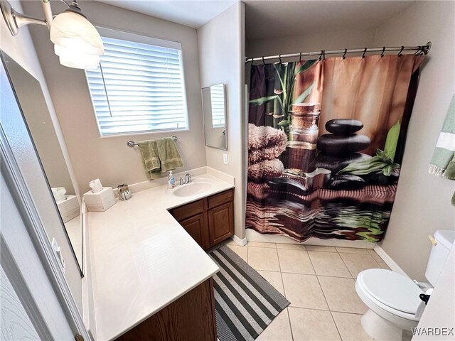 bathroom with toilet, curtained shower, tile patterned flooring, and vanity