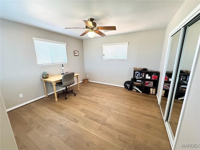 office space featuring light wood-style floors, plenty of natural light, baseboards, and ceiling fan