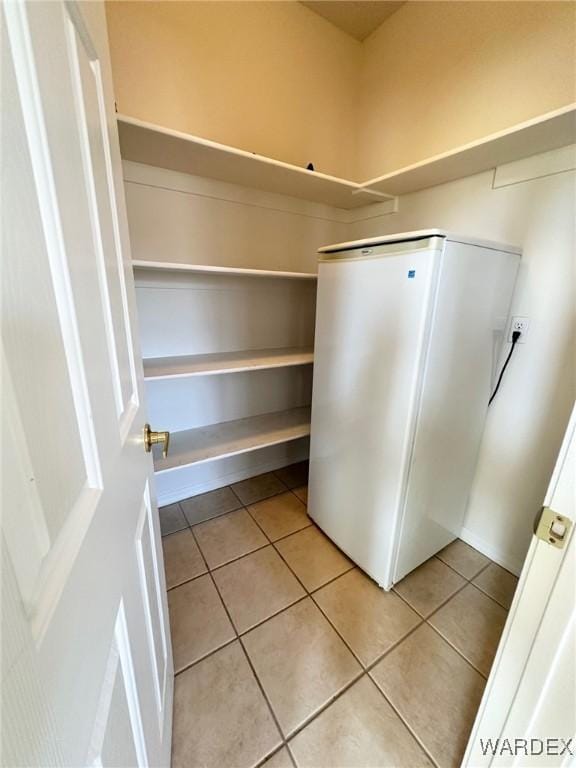 walk in closet with light tile patterned floors