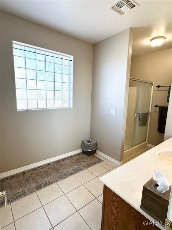 bathroom featuring a stall shower, plenty of natural light, tile patterned flooring, and visible vents