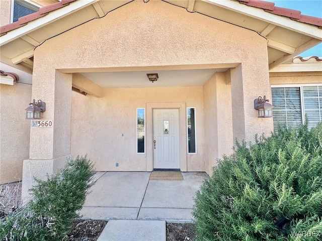 entrance to property featuring stucco siding