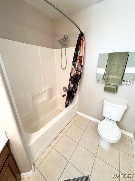 bathroom with toilet, baseboards, shower / tub combo with curtain, and tile patterned floors