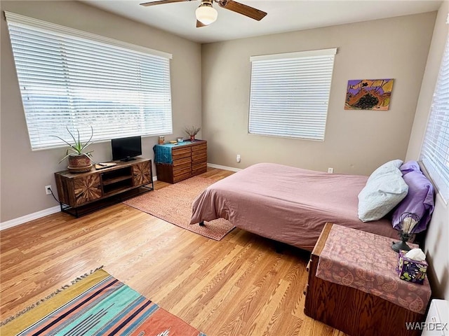 bedroom with ceiling fan, baseboards, and wood finished floors