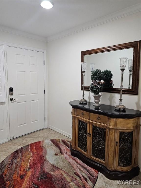 entryway featuring ornamental molding, baseboards, and light tile patterned floors