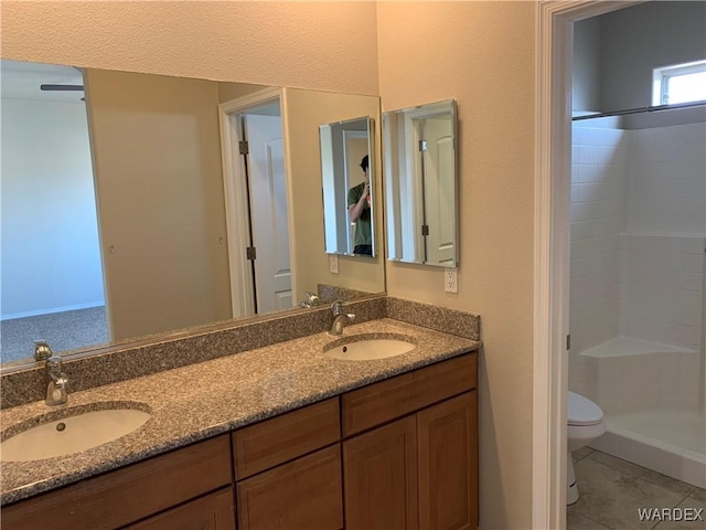 bathroom with double vanity, a shower stall, and a sink