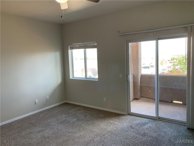 unfurnished room with carpet floors, a ceiling fan, and baseboards