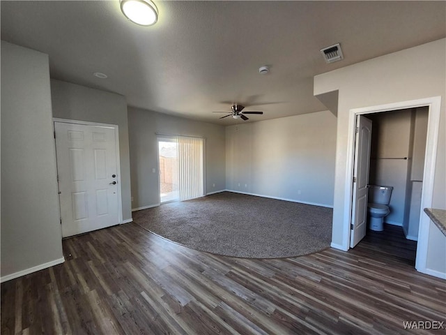 unfurnished bedroom with ensuite bath, baseboards, visible vents, and dark wood finished floors