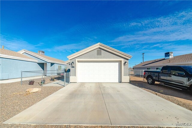 view of front of house featuring concrete driveway, fence, an outdoor structure, and stucco siding