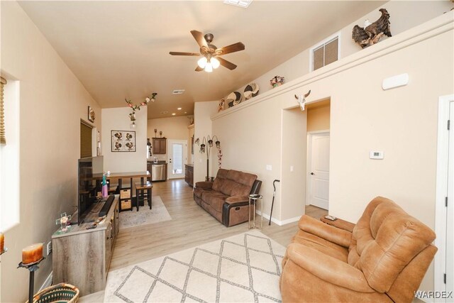 living area with light wood-type flooring, ceiling fan, and visible vents