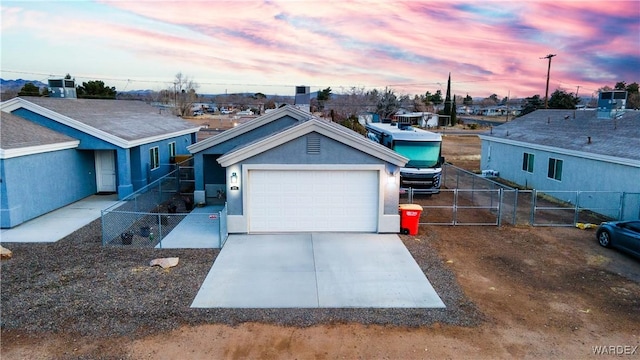 ranch-style home with a garage, fence, concrete driveway, a gate, and stucco siding