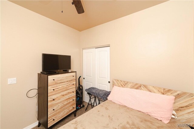 carpeted bedroom featuring a closet, a ceiling fan, and baseboards