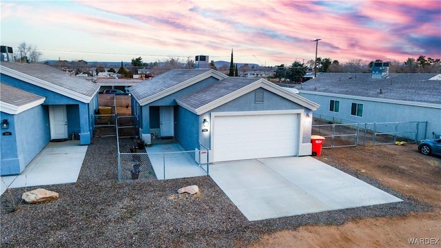 single story home featuring a garage, driveway, fence, and stucco siding