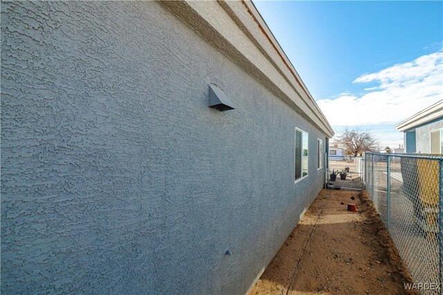 view of property exterior featuring fence and stucco siding