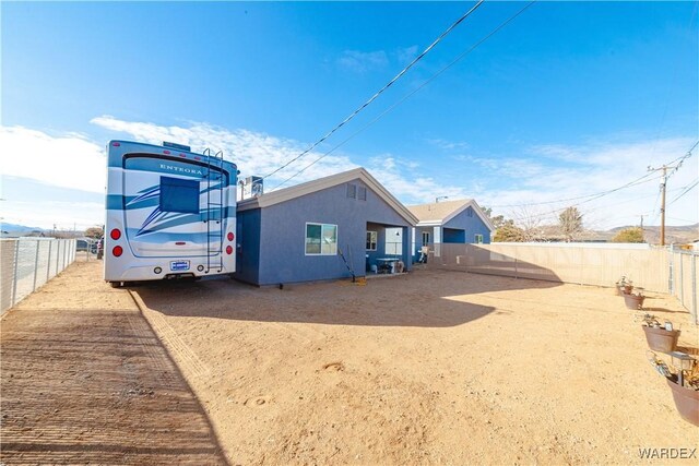 back of property with a fenced backyard and stucco siding