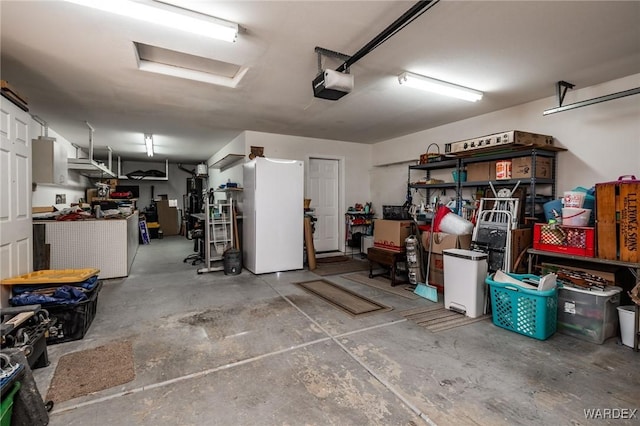 garage featuring freestanding refrigerator and a garage door opener