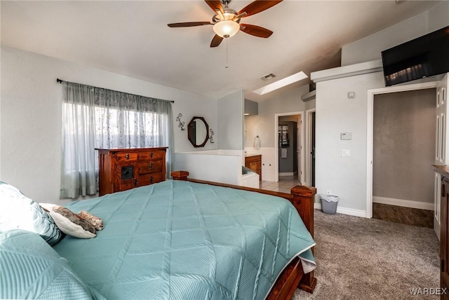 carpeted bedroom with baseboards, visible vents, lofted ceiling, ensuite bath, and ceiling fan