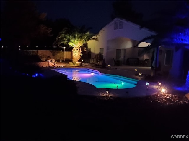 pool at twilight with a fenced in pool, a fenced backyard, and a patio