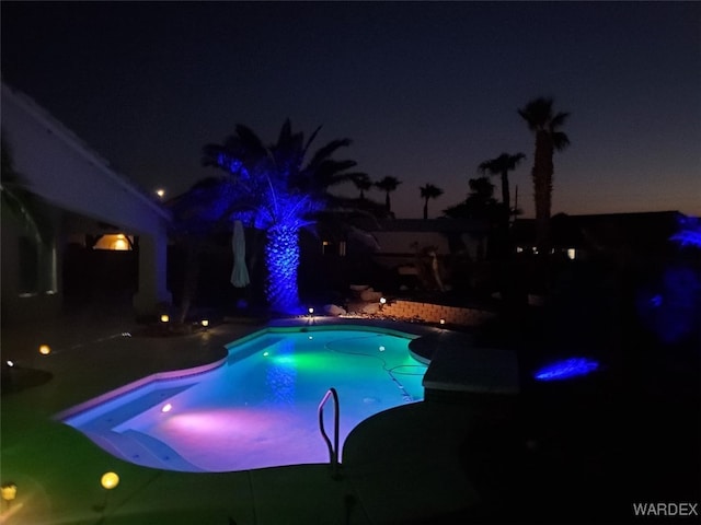 pool at twilight featuring an outdoor pool