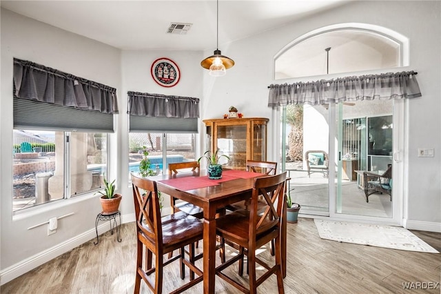 dining space featuring visible vents, baseboards, and wood finished floors