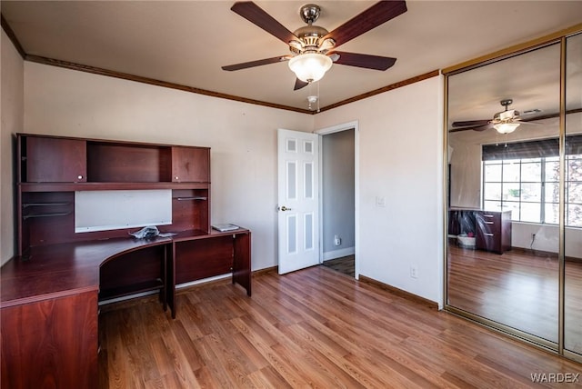 home office featuring a ceiling fan, baseboards, ornamental molding, and wood finished floors