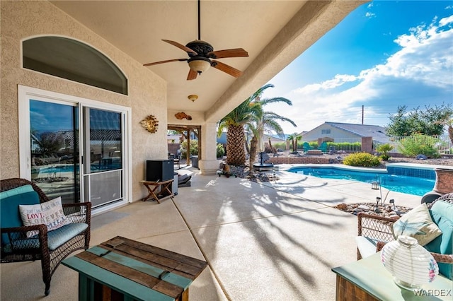 view of patio featuring an outdoor pool, fence, and ceiling fan