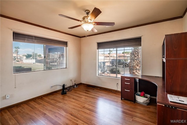 interior space featuring a ceiling fan, baseboards, ornamental molding, and wood finished floors