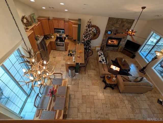 living room featuring recessed lighting, stone finish floor, and a fireplace