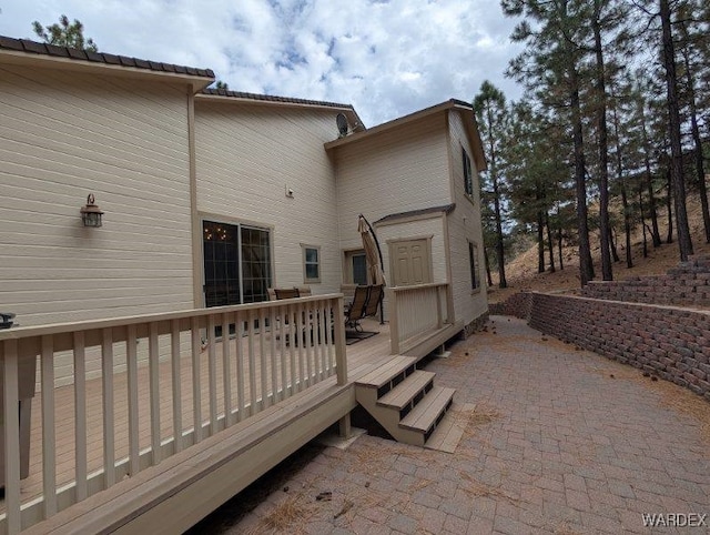 back of property featuring a patio area and a wooden deck