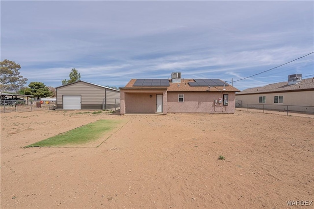 2970 E Devlin Ave, Kingman, AZ 86409 - rear view of property featuring a fenced backyard, solar panels, stucco siding, and a detached garage