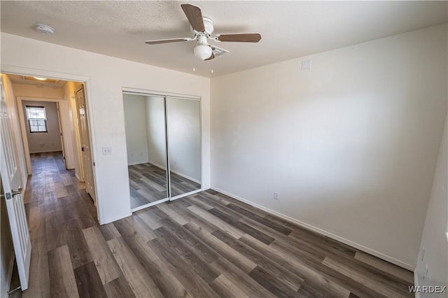 2970 E Devlin Ave, Kingman, AZ 86409 - unfurnished bedroom with attic access, a ceiling fan, baseboards, a closet, and dark wood-style floors