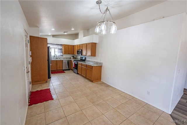 2970 E Devlin Ave, Kingman, AZ 86409 - kitchen with brown cabinetry, a sink, light countertops, stainless steel appliances, and light tile patterned flooring