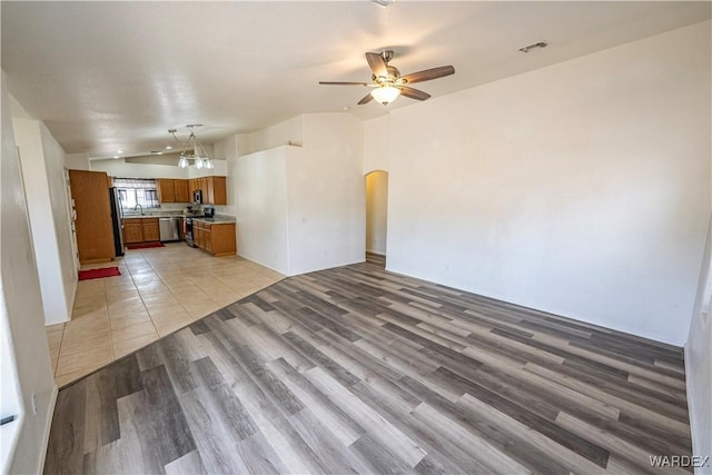 2970 E Devlin Ave, Kingman, AZ 86409 - unfurnished living room with visible vents, lofted ceiling, light wood-style floors, ceiling fan, and arched walkways