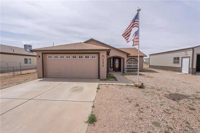 2970 E Devlin Ave, Kingman, AZ 86409 - view of front of house with a garage, stucco siding, fence, and concrete driveway