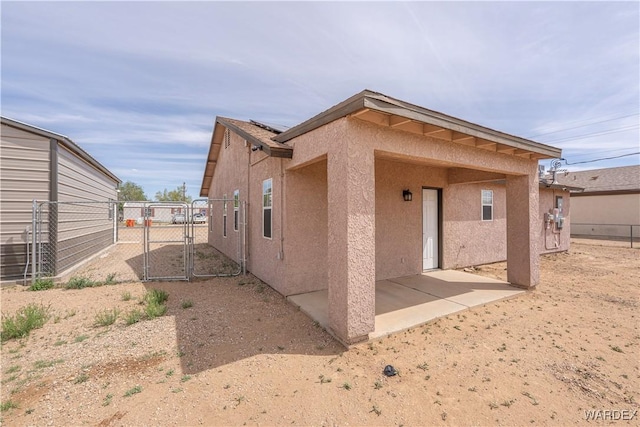 2970 E Devlin Ave, Kingman, AZ 86409 - rear view of property featuring a patio, fence, a gate, and stucco siding
