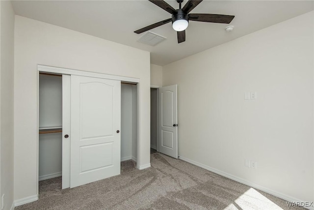 unfurnished bedroom with light carpet, a closet, visible vents, and baseboards