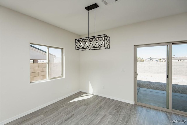 spare room featuring visible vents, baseboards, and wood finished floors