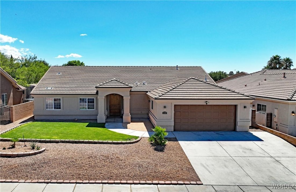 view of front of property featuring stucco siding, concrete driveway, an attached garage, fence, and a tiled roof