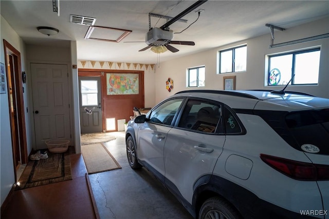 garage featuring a garage door opener and visible vents