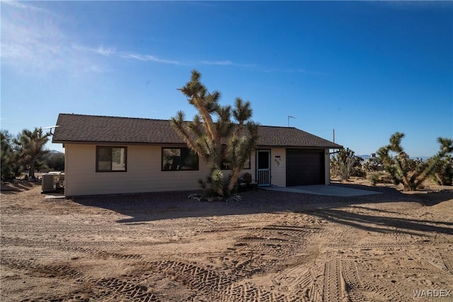 ranch-style house with a garage and central air condition unit