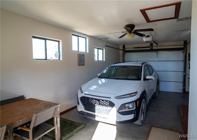 garage featuring baseboards, visible vents, and a garage door opener