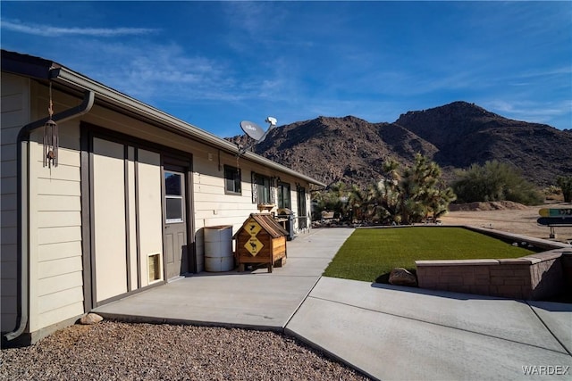 exterior space with a yard, a patio area, and a mountain view