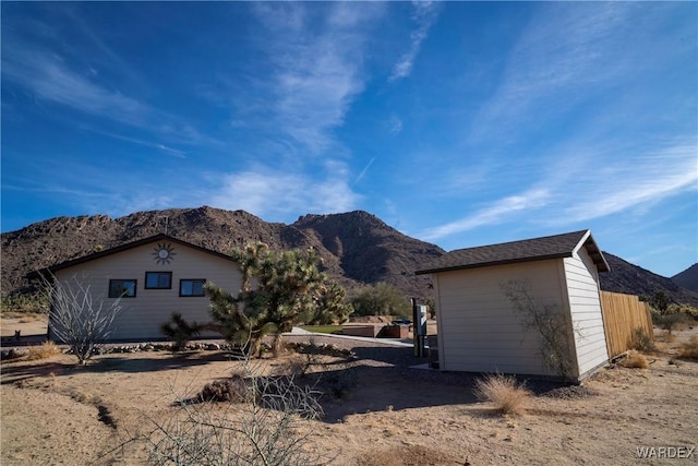 view of side of home featuring fence and a mountain view