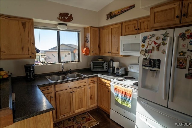 kitchen featuring brown cabinets, a toaster, dark countertops, a sink, and white appliances