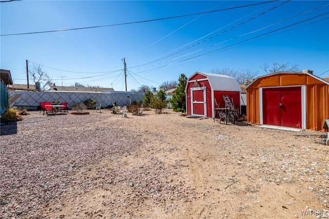 view of yard with an outdoor structure, fence, and a shed